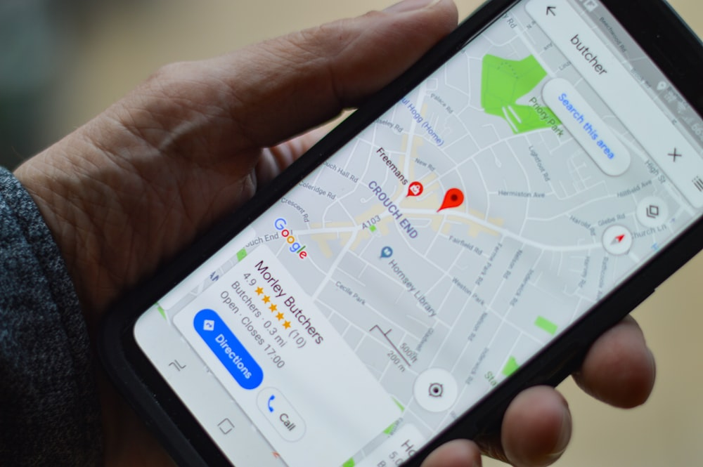 A person holding a phone with a Google Map for a local business